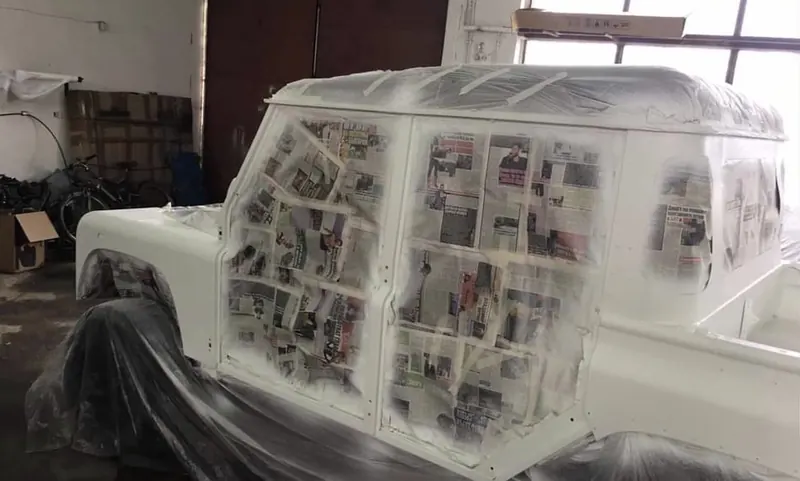 The Defender body masked with newspaper and tape in the paint shop